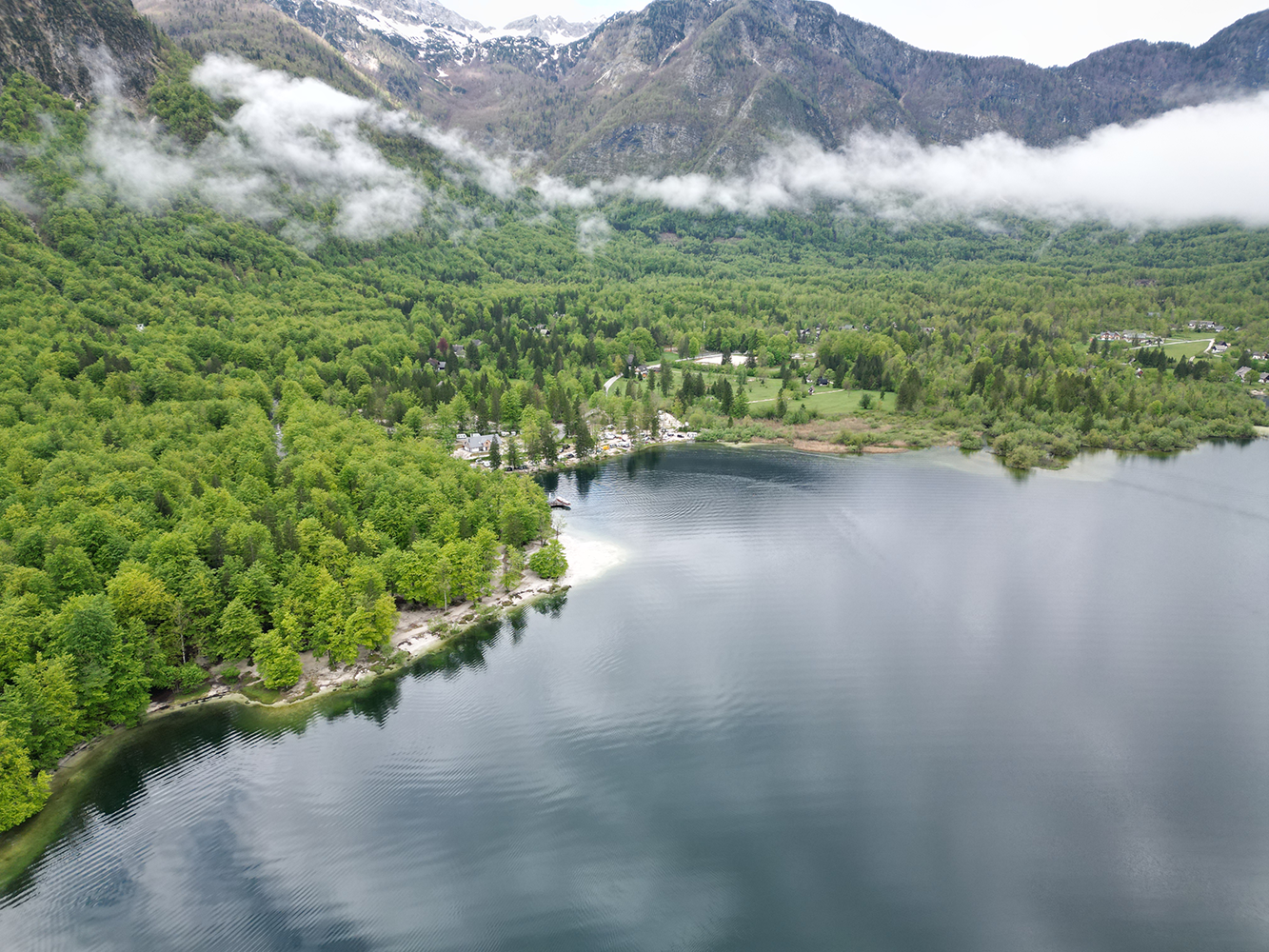 Aerial view of Cerkev Sv. Janeza Krstnika (Church of St. John the Baptist), surrounded by lush greenery and picturesque countryside.