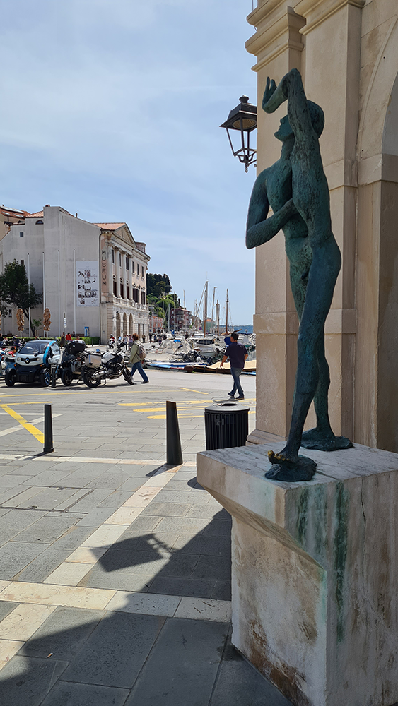 Street view of Piran Old Town, showcasing its narrow cobblestone streets, colorful buildings, and historic charm.