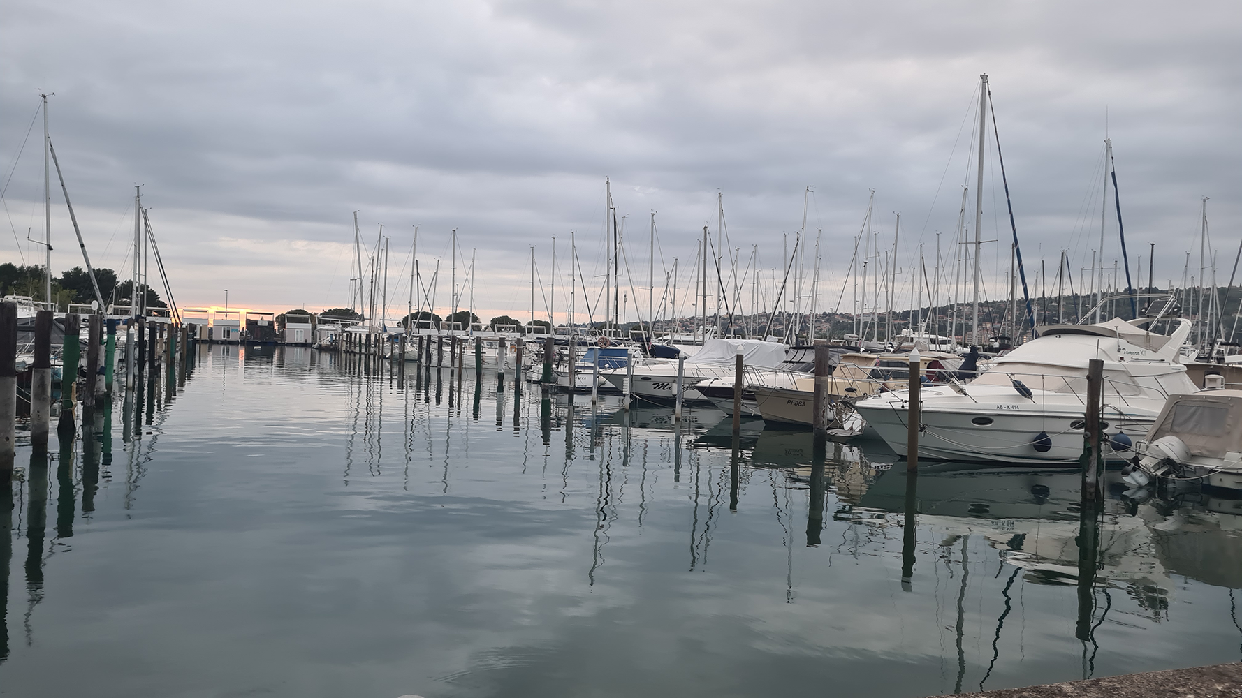 Scenic view overlooking Piran Harbor, with boats moored in the harbor and the picturesque town of Piran in the background.