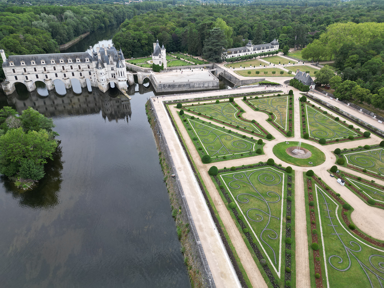 Aerial view of the gardens of Château de Chenonceau, showcasing its intricate design and lush greenery.