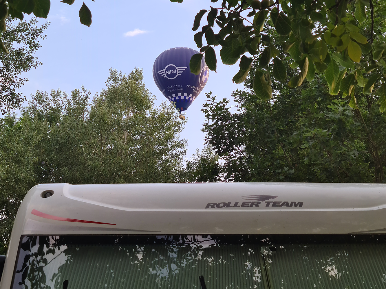Rollerteam motorhome with a hot air balloon overhead, showcasing a picturesque travel scene.