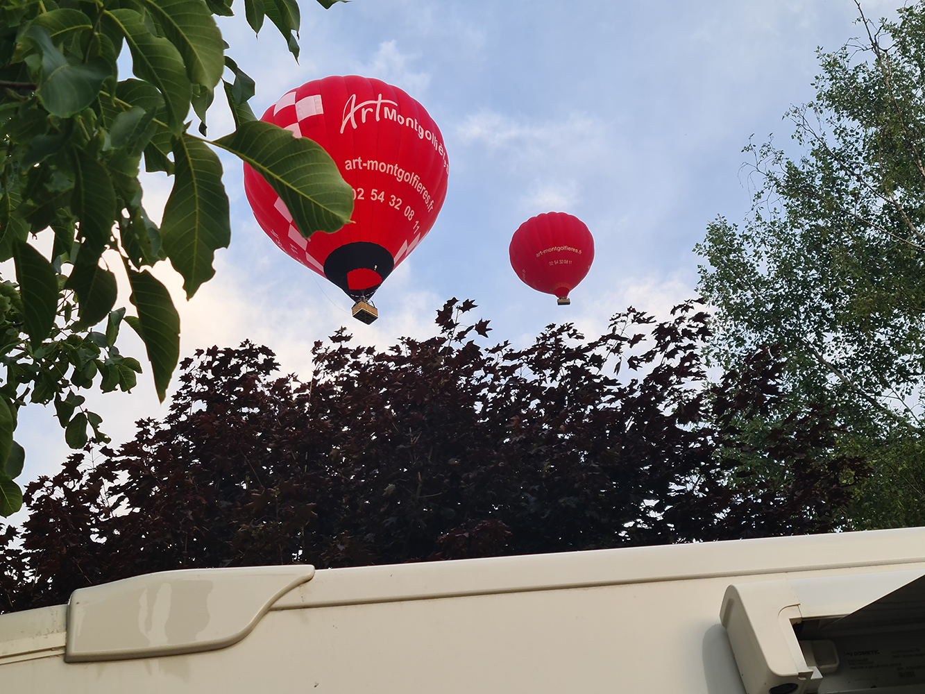 Rollerteam motorhome with a hot air balloon overhead, showcasing a picturesque travel scene.