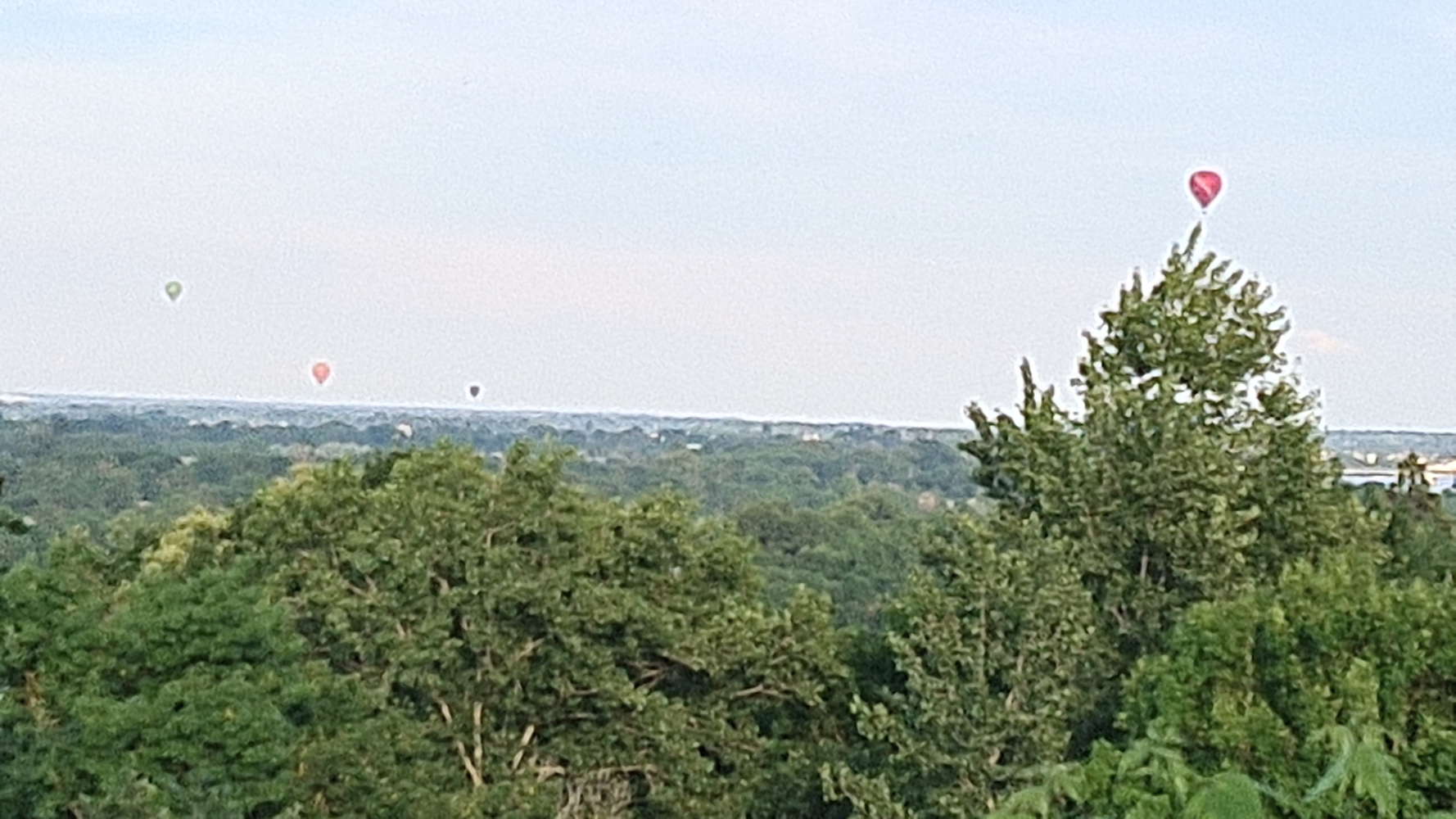 Breathtaking view from Camping Huttopia Saumur overlooking the Loire Valley, with rolling hills and the majestic river in the distance.