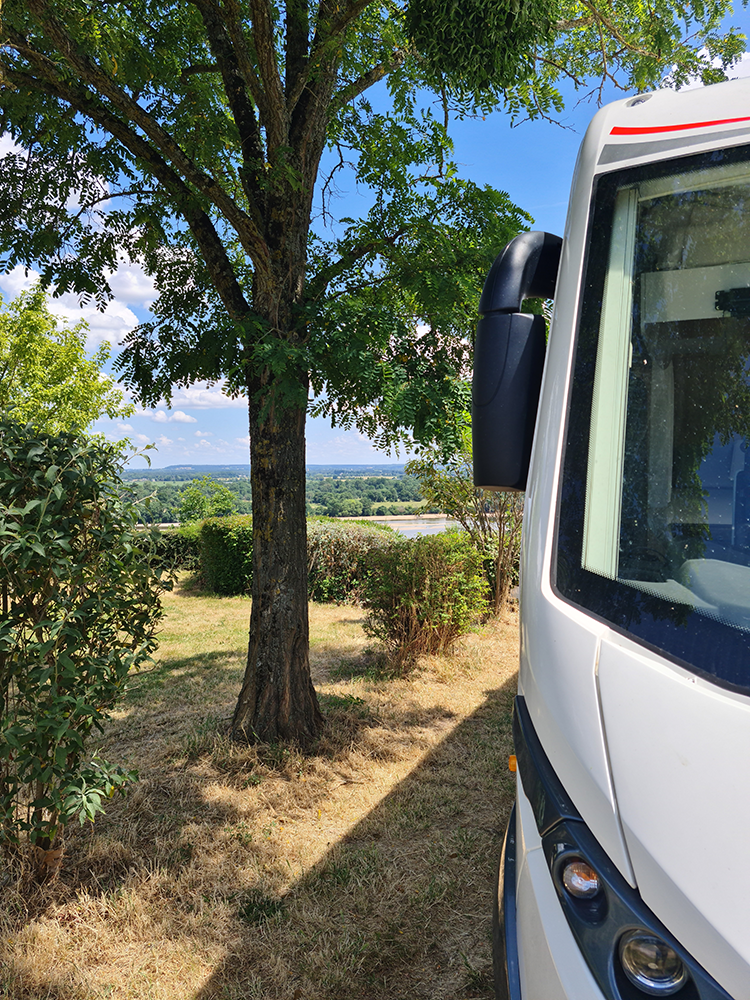 Scenic view from a motorhome at Camping Huttopia Saumur, overlooking the breathtaking Loire Valley with rolling hills and the majestic Loire River.