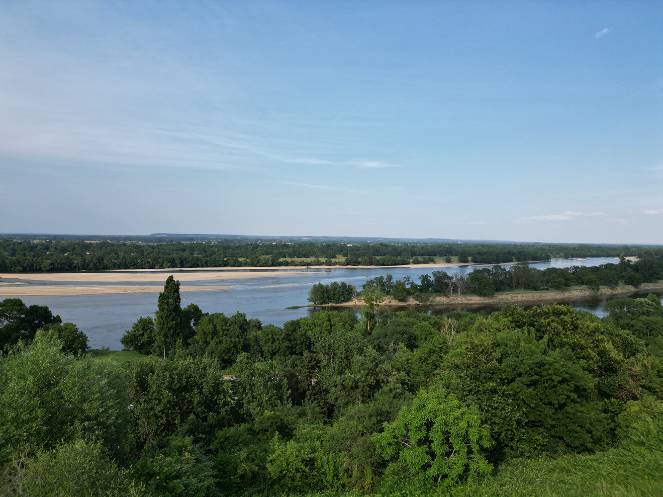 Panoramic view from Camping Huttopia Saumur, showcasing the breathtaking beauty of the Loire Valley with rolling hills and the majestic Loire River.