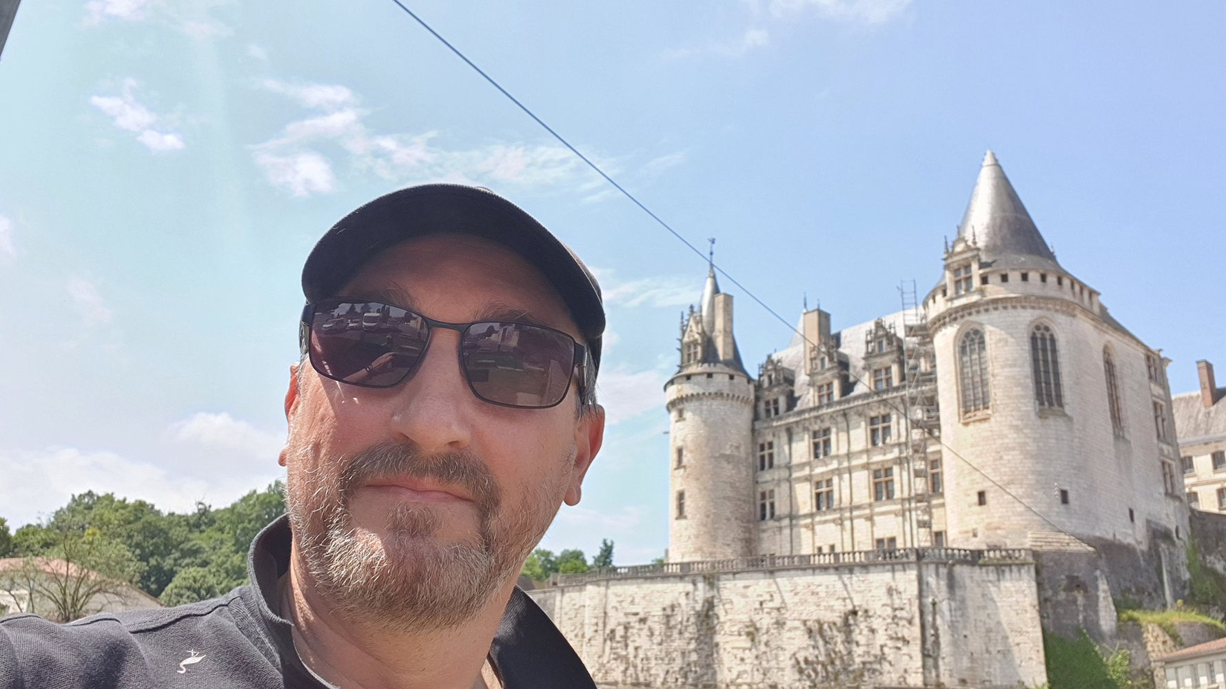 A cheerful selfie with Château de La Rochefoucauld in the background, showcasing the historic castle's stunning architecture.