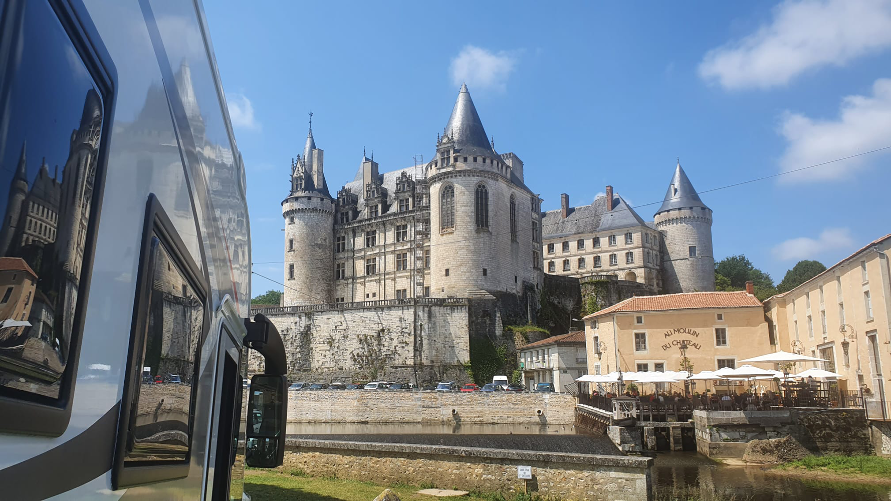 Front view of Château de La Rochefoucauld from the parking area, showcasing the castle's impressive façade and surrounding landscape.