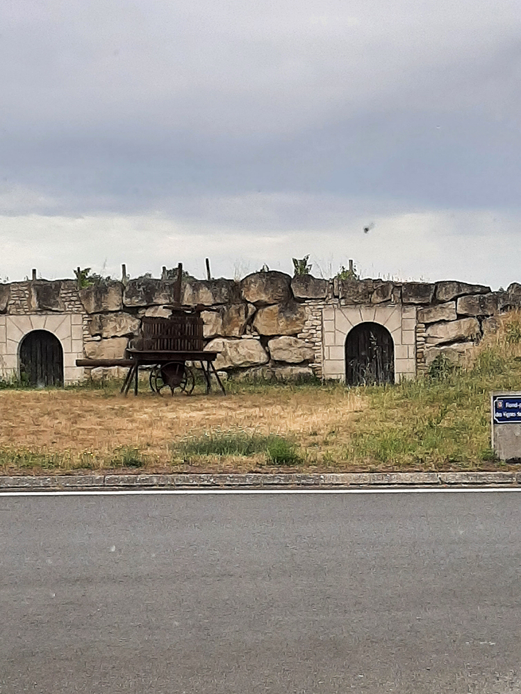 Historic tunnel at Château de La Rochefoucauld, with stone walls and an arched ceiling, leading to a hidden passage.