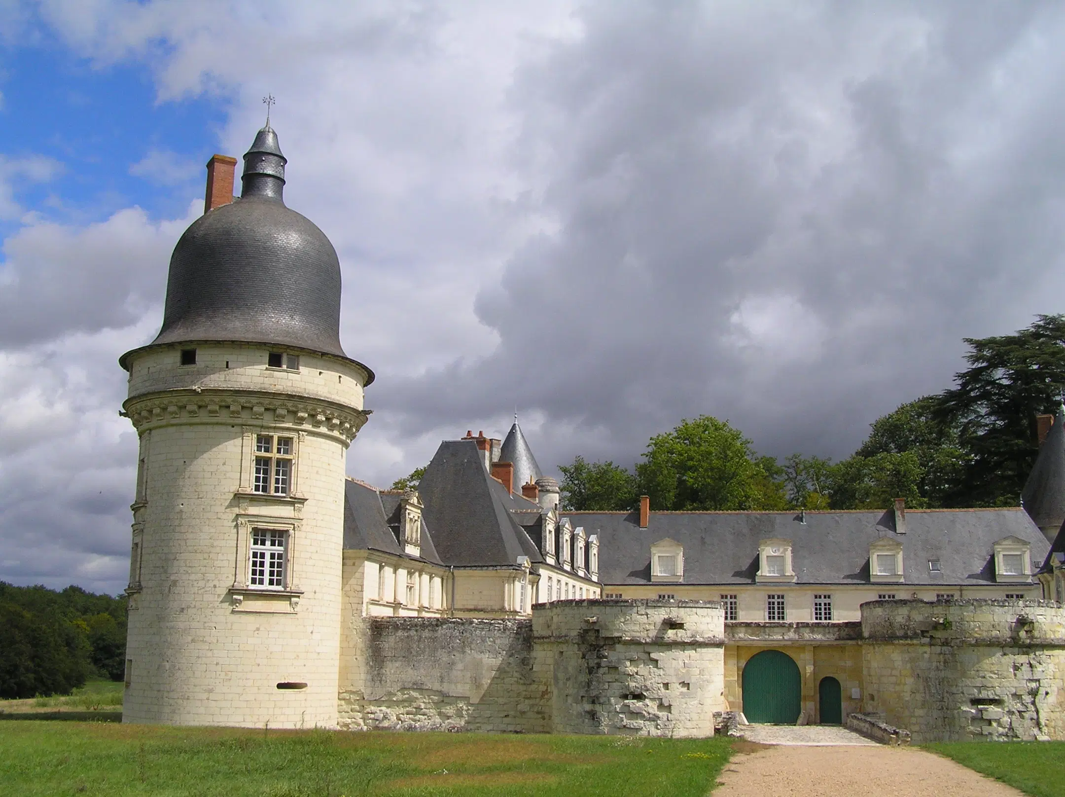 Exterior view of the entrance to Château du Gué-Péan, surrounded by a moat and lush greenery.