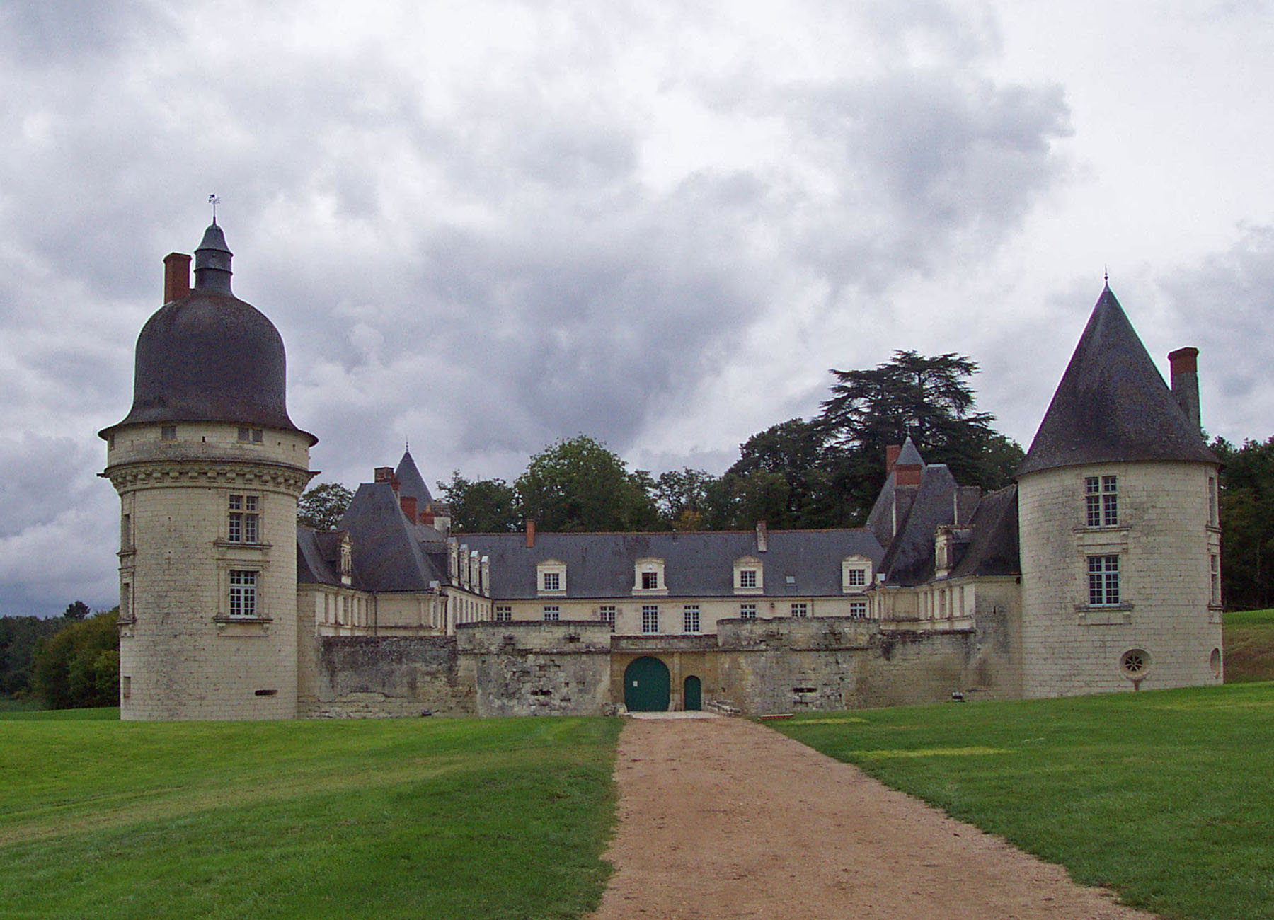 Exterior view of the entrance to Château du Gué-Péan, surrounded by a moat and lush greenery.
