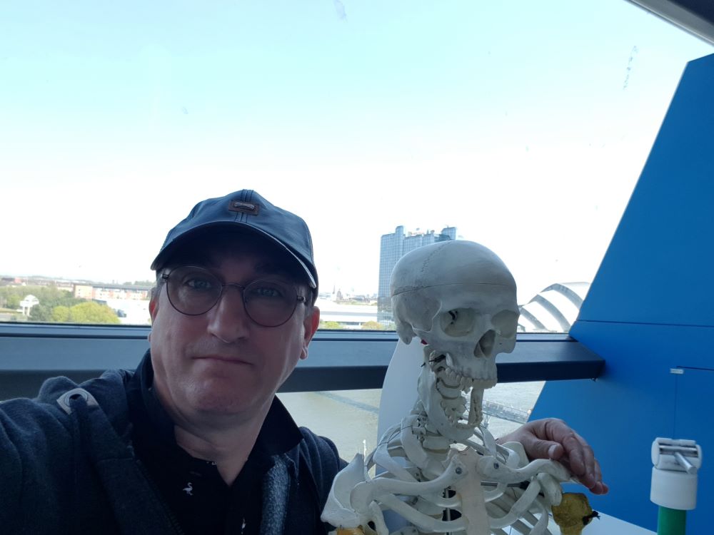 Person standing next to a skeleton exhibit inside Glasgow Science Centre