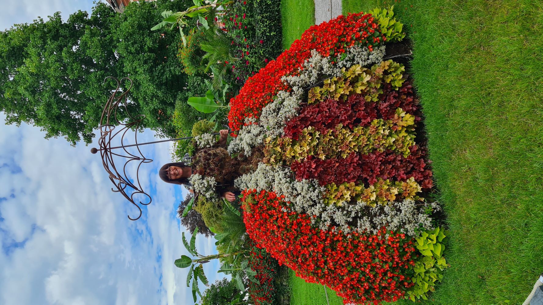 Artisans making a dress of flowers on Mainau Island, surrounded by lush greenery.