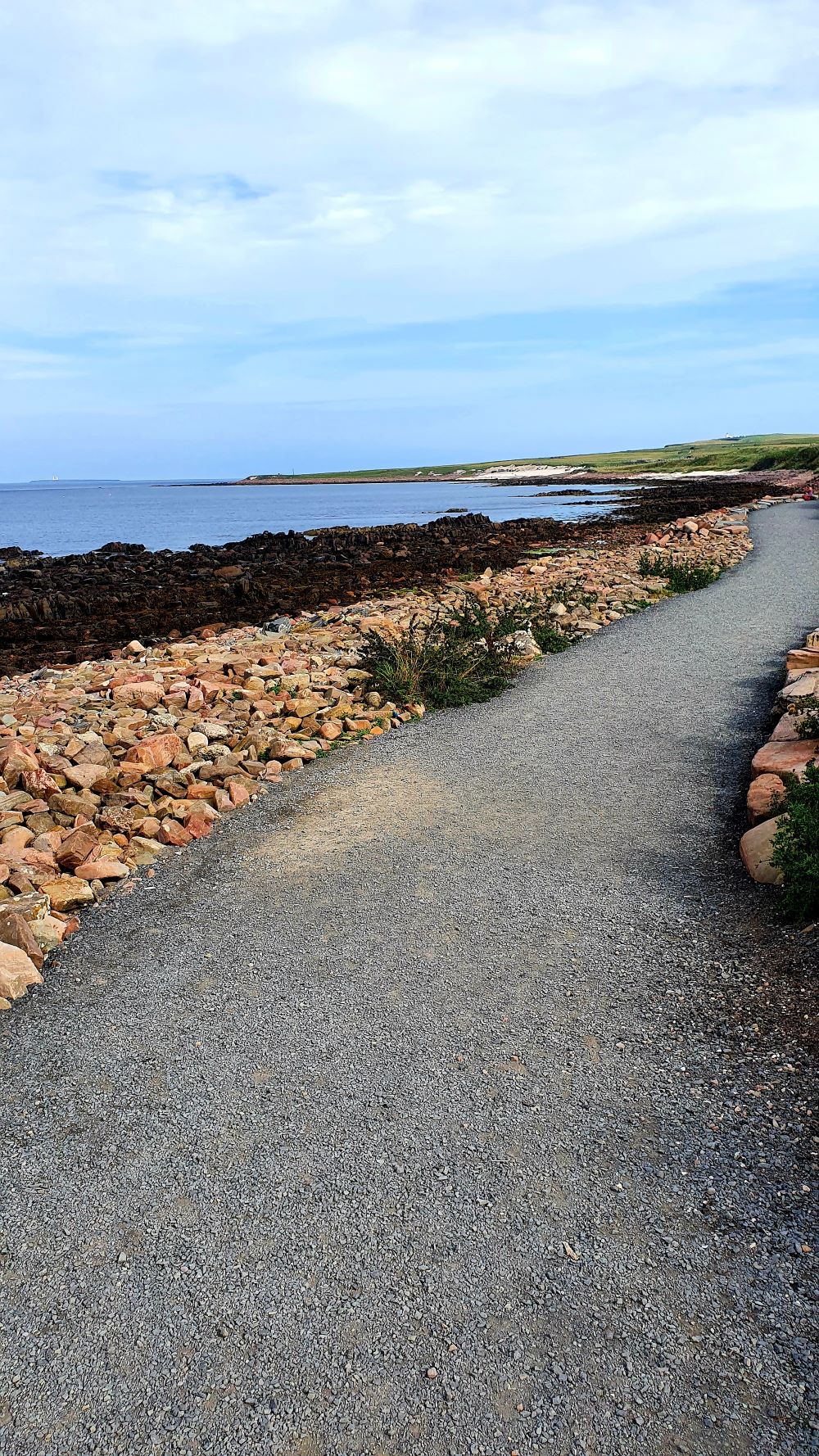 Trail signpost in John o'Groats, indicating hiking routes and directions.
