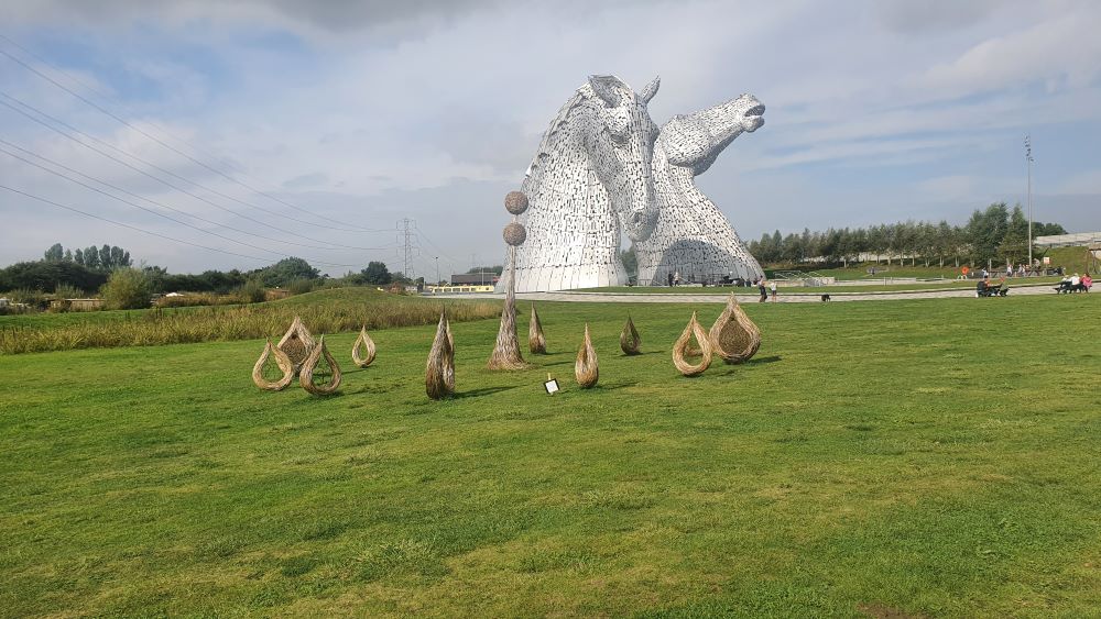 View of the Kelpies sculptures from a distance, against a cloudy sky
