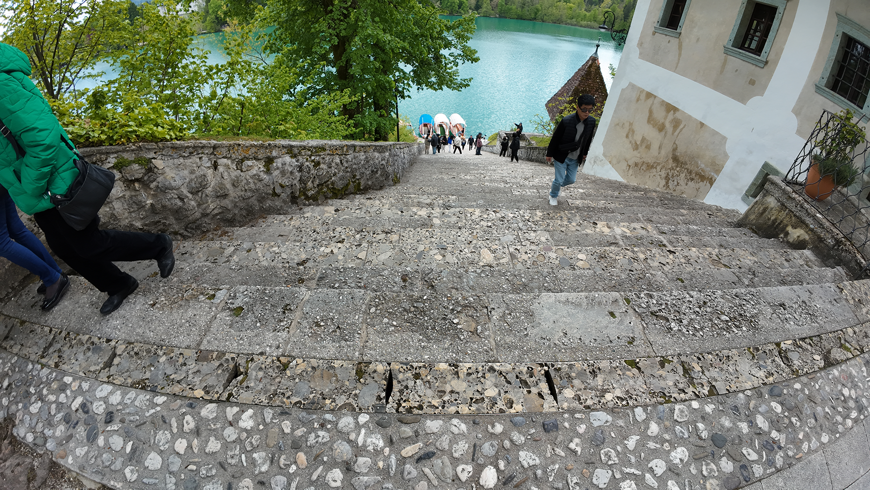 View of Bled Island with the stone steps descending to the shore, surrounded by the tranquil waters of Lake Bled.