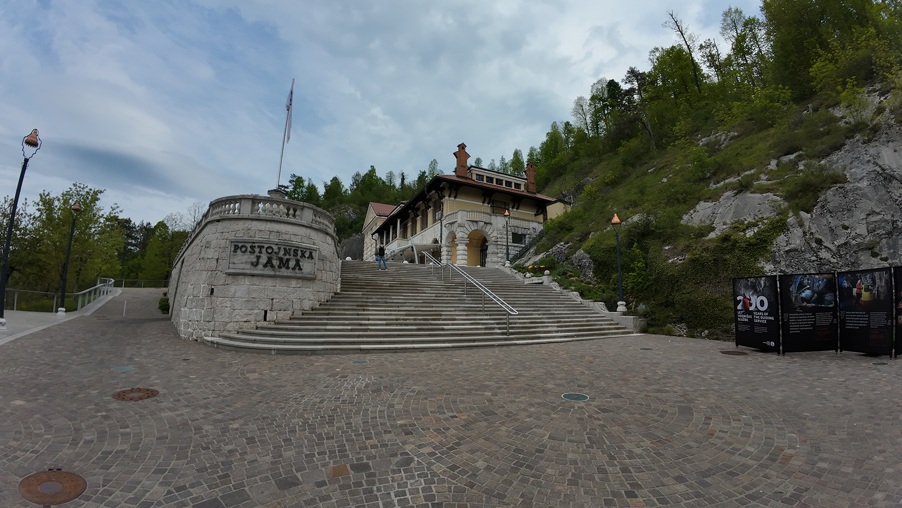 Staircase leading to the exit of Postojna Cave, with visitors ascending from the underground depths.