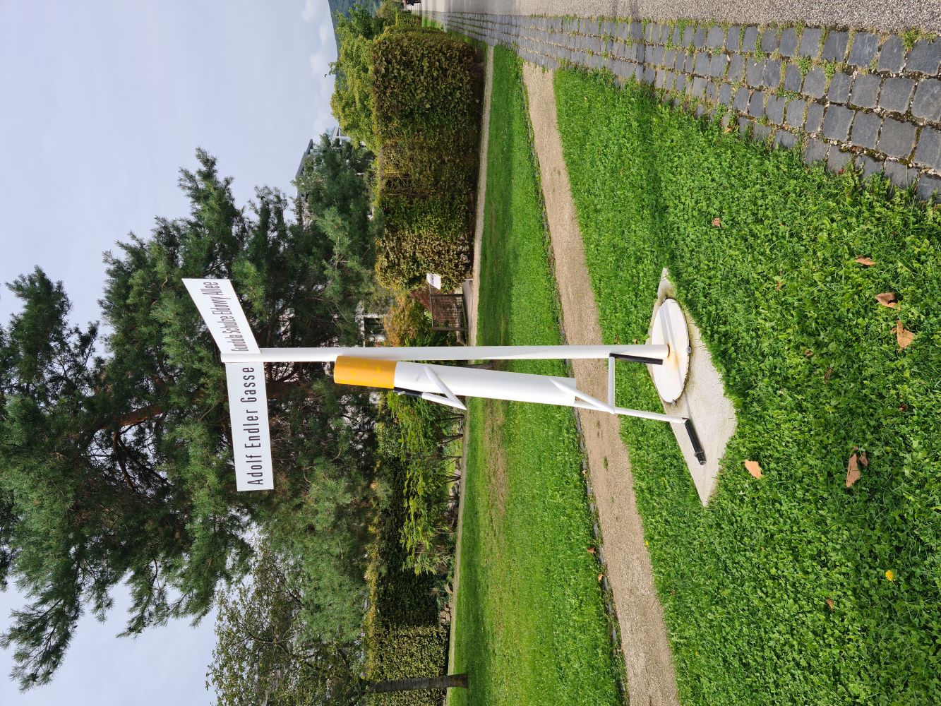 Statue of a cigarette next to the Rhine River, with the scenic waterway and surrounding landscape in the background.