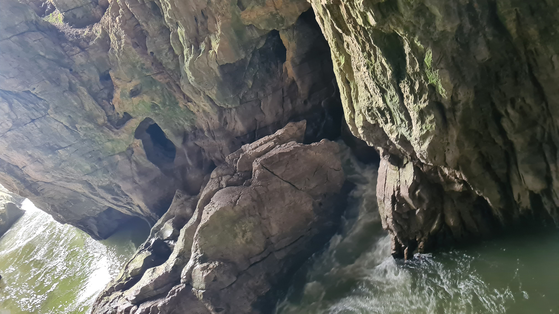 Crystal-clear pool of water inside Skocjan Caves, reflecting the majestic limestone formations.