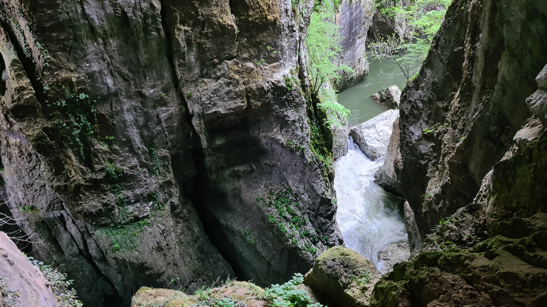 "Waterfall inside Skocjan Caves, cascading down the rugged limestone formations into a crystal-clear pool.
